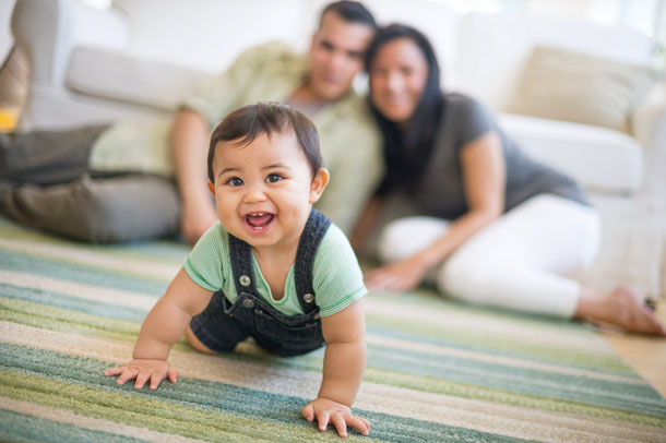 Baby crawling with parents watching