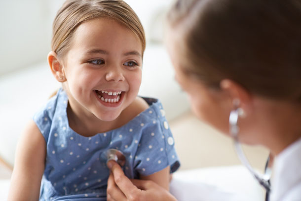 A young girl smiling at a doctor