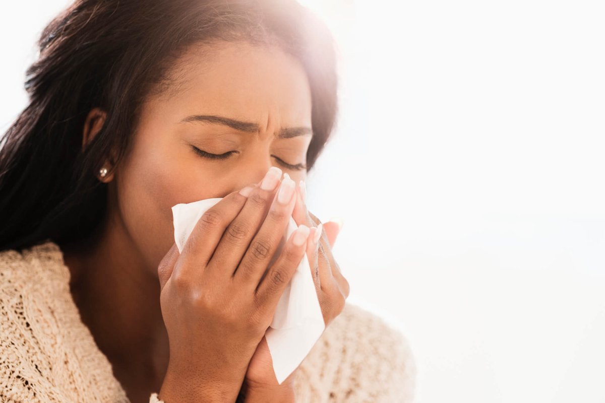 Woman blowing nose.